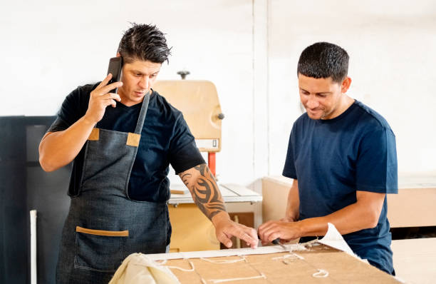 furniture manufacturing business owner talking on phone in workshop - home decoration stock pictures, royalty-free photos & images