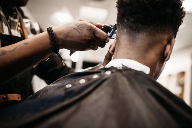 geben einen neuen haarschnitt in seinem geschäft barber - hairstyle stock-fotos und bilder