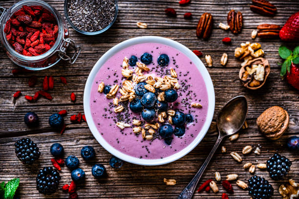 gemengde bessen smoothie bowl op rustieke houten tafel. - food stockfoto's en -beelden
