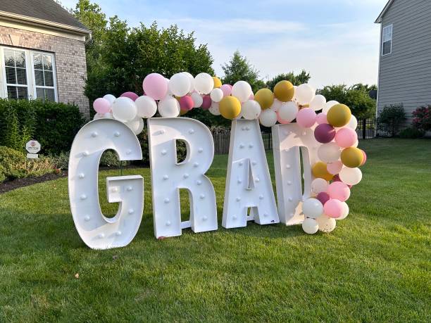 Giant light up Grad sign with Balloons in front of home during graduation season, Virginia.