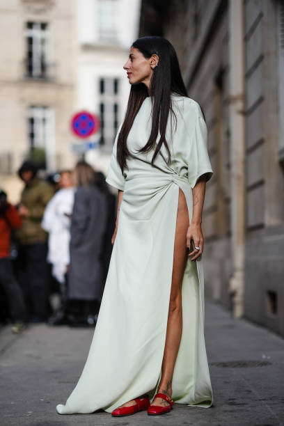 Gilda Ambrosio wears a pastel pale green long flowing slit dress , red leather shoes, outside Valentino, during the Womenswear Fall/Winter 2024/2025...