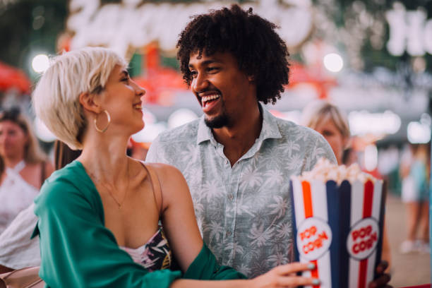 girl and boy eating popcorns - concert stock pictures, royalty-free photos & images
