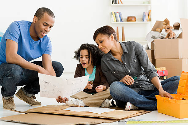 girl and parents building furniture - home decoration stock pictures, royalty-free photos & images