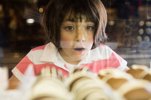 girl awed by chocolate bonbons in glass case - food stock pictures, royalty-free photos & images