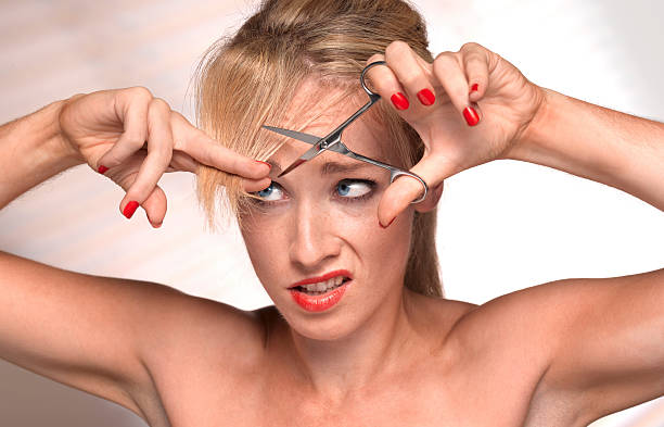 girl cutting own hair - hairstyle stock pictures, royalty-free photos & images