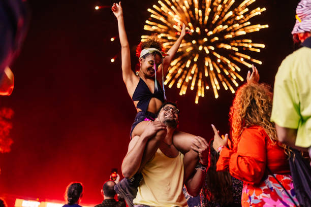 girl on boyfriends shoulders at festival - concert stock pictures, royalty-free photos & images