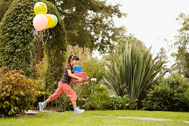 girl running at birthday party - garden decoration stock pictures, royalty-free photos & images