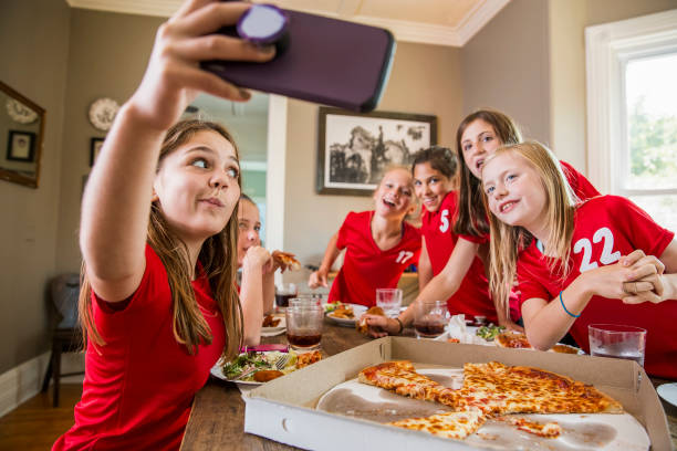 girl taking selfie with friends while eating pizza - junk food stock pictures, royalty-free photos & images