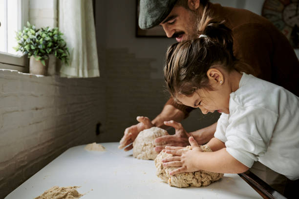 girl with her father making strength while kneading bread - food fotografías e imágenes de stock