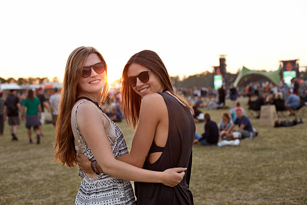 girlfriends posing to camera at big festival - concert stock pictures, royalty-free photos & images