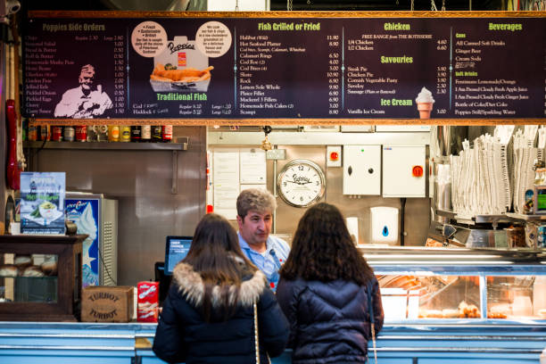 girls queuing at fish and chips counter, london, uk - junk food stock pictures, royalty-free photos & images