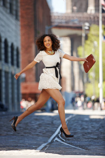 glamorous mixed race woman running on urban street - fashion stock pictures, royalty-free photos & images