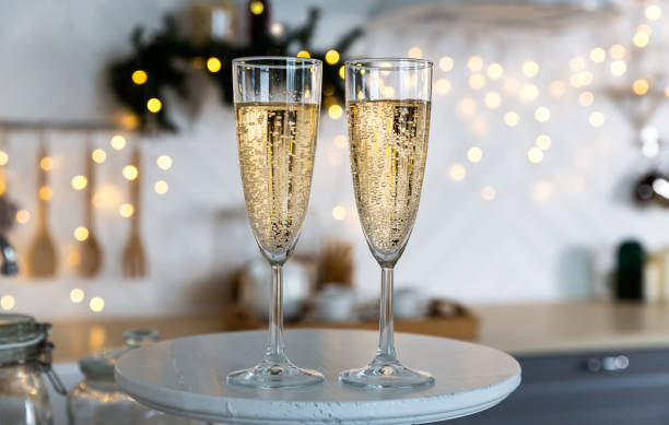glasses with champagne on the background of christmas decorations. - home decoration stock pictures, royalty-free photos & images