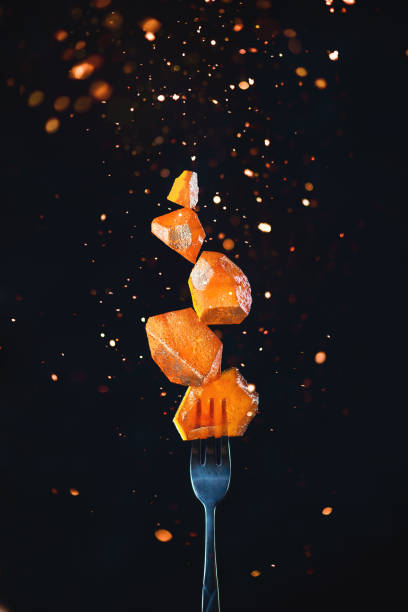 golden marmalade block on a fork with sparks and flares. action food photography on a dark background with copy space. gourmet dessert concept. - food stock pictures, royalty-free photos & images