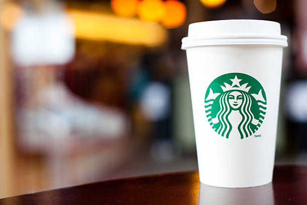 grande starbucks to go cup on table - junk food stock pictures, royalty-free photos & images