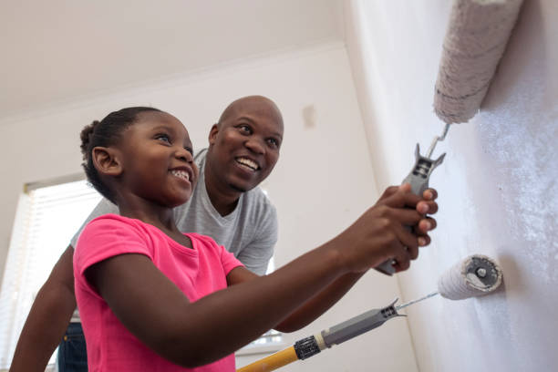 grandes sonrisas como hija ayuda a padre de la pintura cercanas vista de ángulo bajo - home decoration fotografías e imágenes de stock
