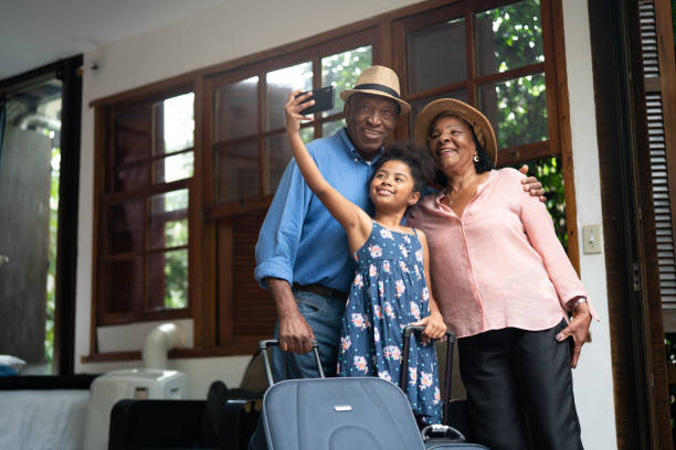 grandparents and granddaughter taking selfies after arriving in a hotel - travel stock pictures, royalty-free photos & images