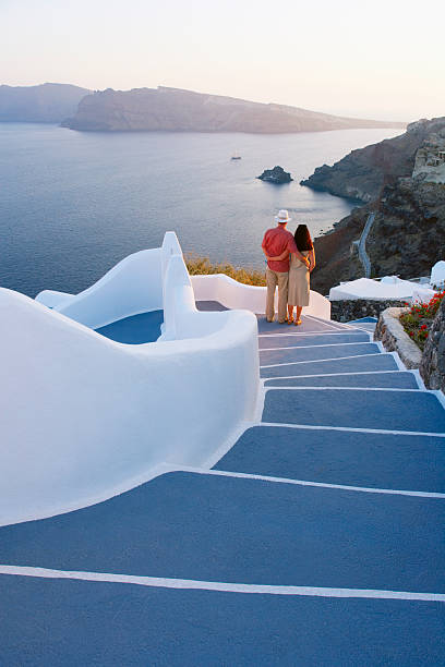 greece, the cyclades, santorini, couple embracing on steps, rear view - travel stock pictures, royalty-free photos & images
