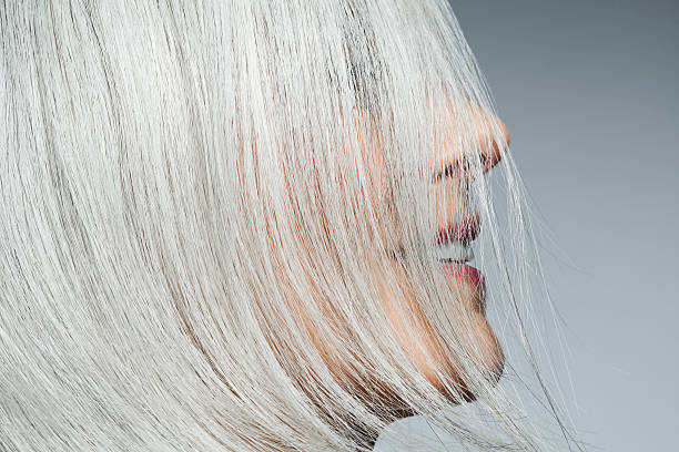 grey haired woman profile with hair covering face. - hairstyle stockfoto's en -beelden