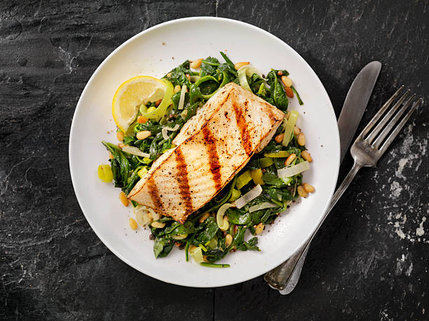 grilled halibut with spinach, leeks and pine nuts - food stock pictures, royalty-free photos & images