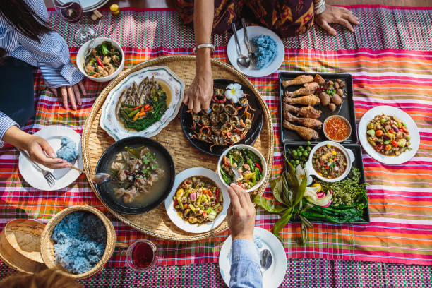 groep aziatische mensenfamilie geniet van het vieren van thais voedseldiner terwijl het zitten op mat thuis, noordoost thailand (issan) gezond traditioneel thais voedselconcept, hoogste mening - food stockfoto's en -beelden