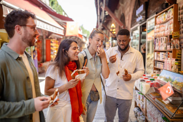 group enjoying street food in a bustling market - food stock pictures, royalty-free photos & images