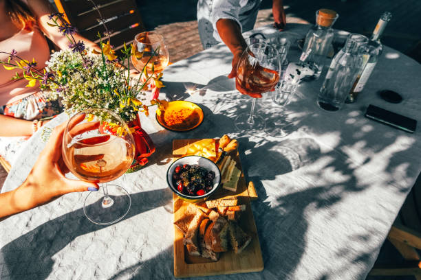 group of female friends drinking wine outside. - food stock pictures, royalty-free photos & images