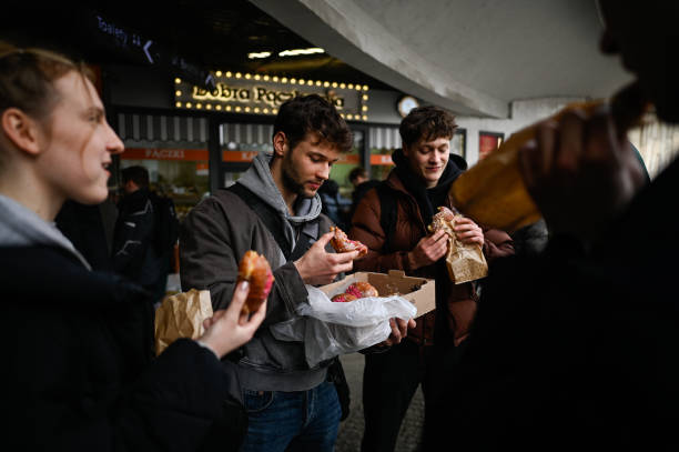 Group of friends eat the Polish donuts during the Fat Thursday in Krakow, Poland on February 27, 2025. The Fat Thursday in Poland, as tradition on...