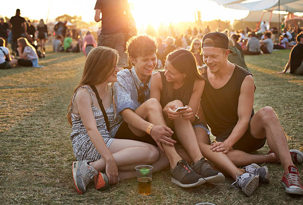 group of friends hanging out on grassfield - concert stock pictures, royalty-free photos & images