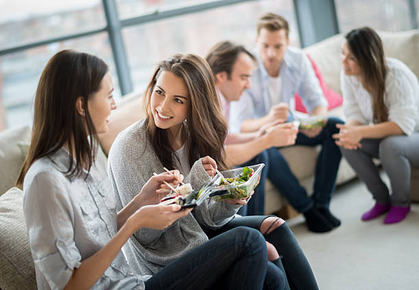 group of friends having dinner - junk food stock pictures, royalty-free photos & images