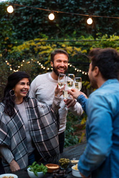 group of friends toasting with champagne during new years party - garden decoration stock pictures, royalty-free photos & images