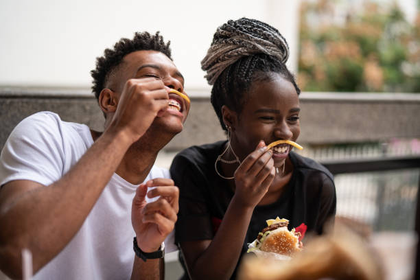group of young people having fun in a restaurant - junk food stock pictures, royalty-free photos & images