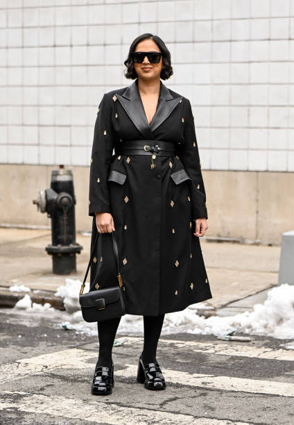 Guest is seen wearing a black and gold embellished coat, black bag, black shoes and black sunglasses outside the Michael Kors show during NYFW F/W...