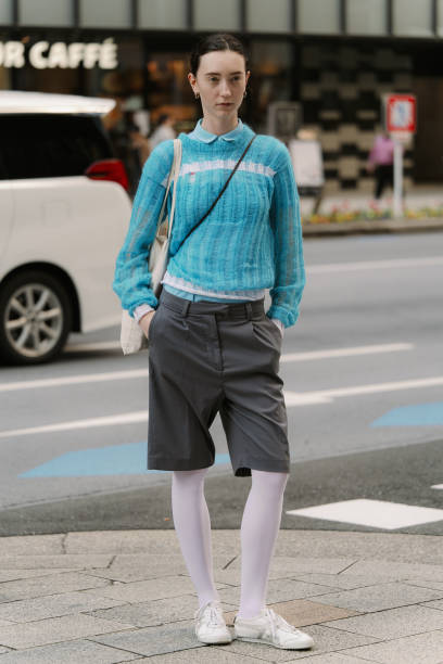 Guest is seen wearing a blue top, grey shorts, white tights, Onitsuka Tiger white sneakers during Rakuten Tokyo Fashion Week A/W 2025 on March 22,...