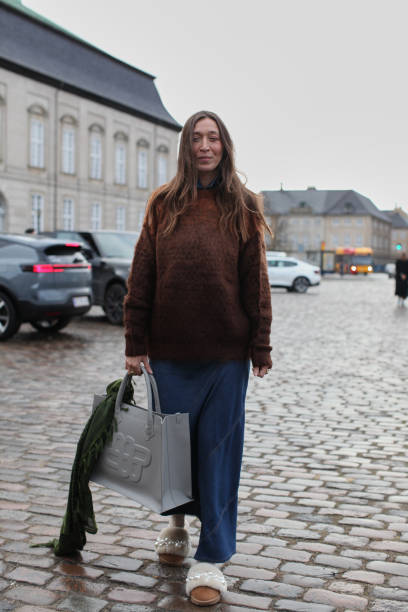 Guest is seen wearing a Brown Jumper with a Long Denim Skirt at Cmmn Swdn. During the Copenhagen Fashion Week Autumn/Winter 2025 on January 30, 2025...