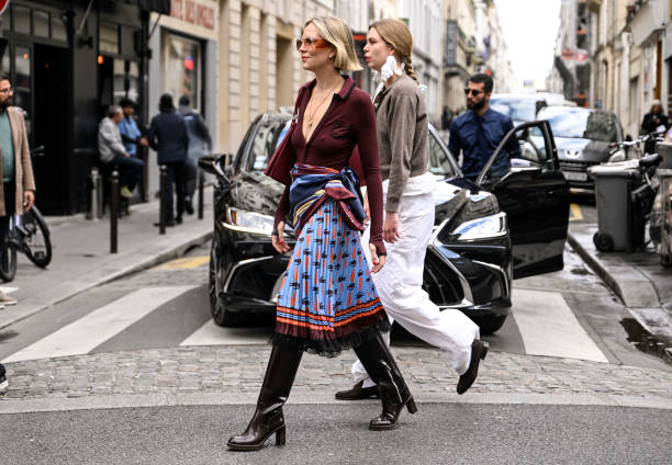 Guest is seen wearing a burgundy Lacoste sweater, Lacoste skirt and knee high boots outside the Lacoste show during Womenswear Spring/Summer 2025 as...