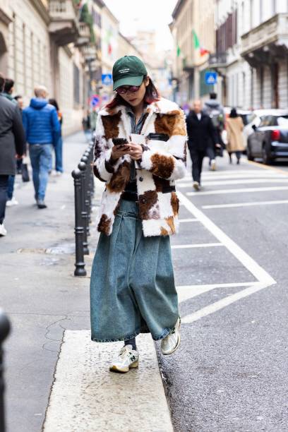 Guest is seen wearing a green hat with white littering details, a long denim skirt, white New Balance sneakers, grey lurex socks, a denim jacket and...
