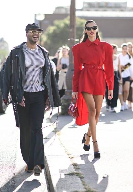 Guest is seen wearing a red Givenchy dress with red bag and black shoes and black sunglasses outside the Givenchy show during the Womenswear...