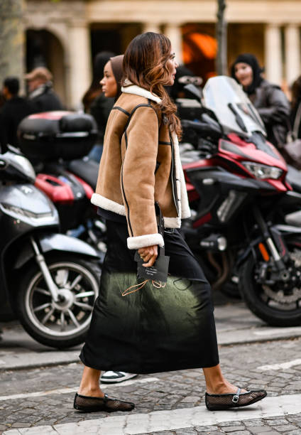 Guest is seen wearing a tan and faux fur jacket, black skirt and Isabel Marant green and black bag outside the Isabel Marant show during Womenswear...
