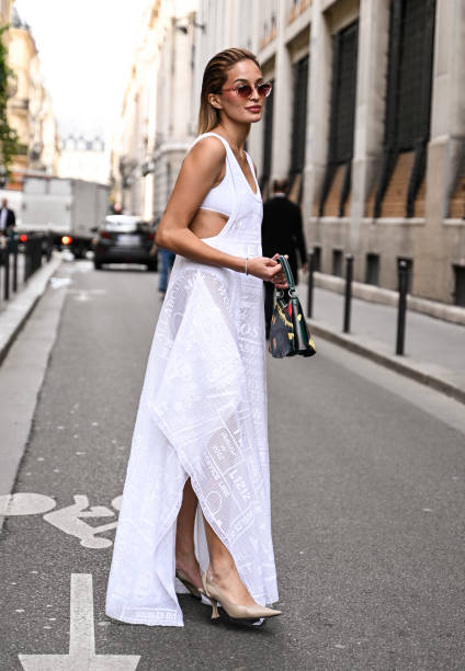 Guest is seen wearing a white Lacoste dress, tan heels and Lacoste bag outside the Lacoste show during Womenswear Spring/Summer 2025 as part of Paris...