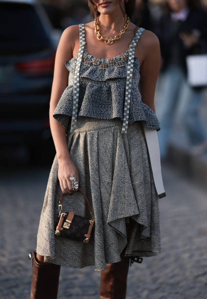 Guest seen wearing Louis Vuitton gold necklace, grey checked ruffled tank top, grey ruffled midi skirt, Louis Vuitton brown monogram canvas / leather...