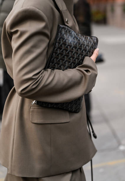 Guest wearing a tan jacket and skirt and black Louis Vuitton handbag outside the Ashlyn show during NYFW F/W 2025 on February 07, 2025 in New York...
