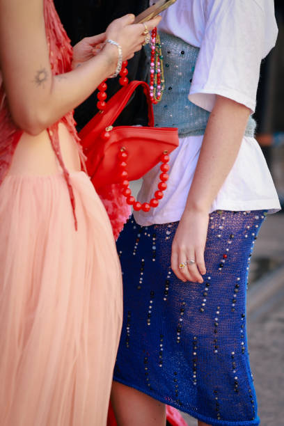 Guest wearing white tshirt, blue corset, denim beaded skirt and red bag during Australian Fashion Week Presented By Pandora 2024 at Carriageworks on...