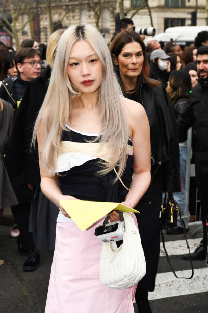 Guest wears a black and white top, a pink skirt a white Miu Miu bag outside Miu Miu show during the Womenswear Fall/Winter 2025/2026 as part of Paris...