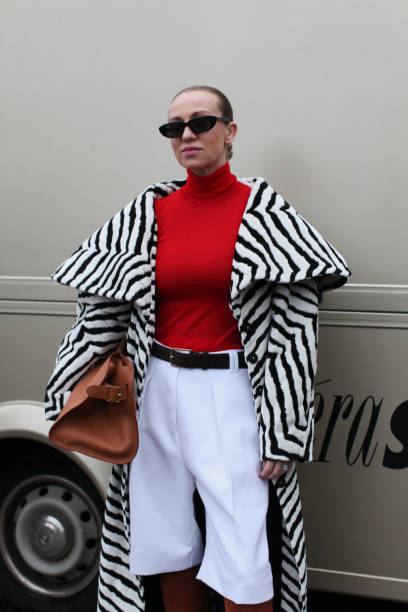 Guest wears a Black & White Animal Print Coat with a Red Polo Neck Jumper at OpéraSport, during the Copenhagen Fashion Week Autumn/Winter 2025 on...
