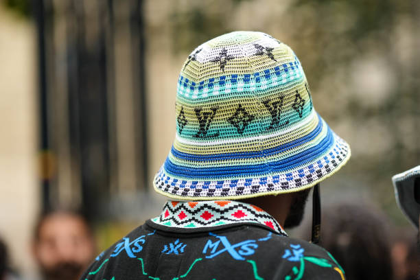 Guest wears a black with neon blue and green embroidered pattern polo shirt, a white / blue / green striped print pattern with embroidered LV black...