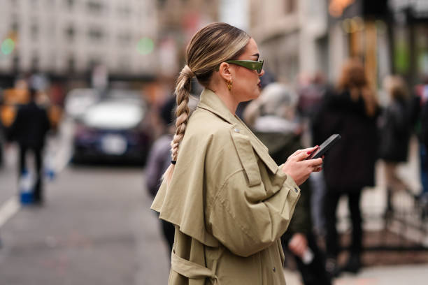 Guest wears a green Prada sunglasses, a beige trench coat, outside La Pointe , during New York Fashion Week, on February 10, 2024 in New York City.