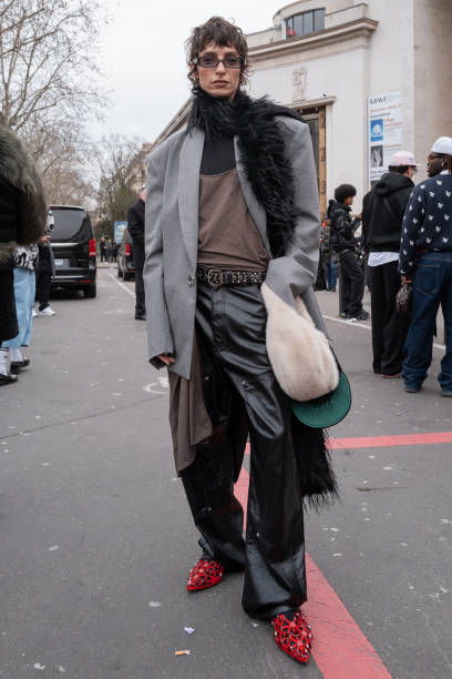 Guest wears a grey oversized blazer a black pants black belt and red shoes outside Rick Owens during the Menswear Fall Winter 2025/2026 as part of...