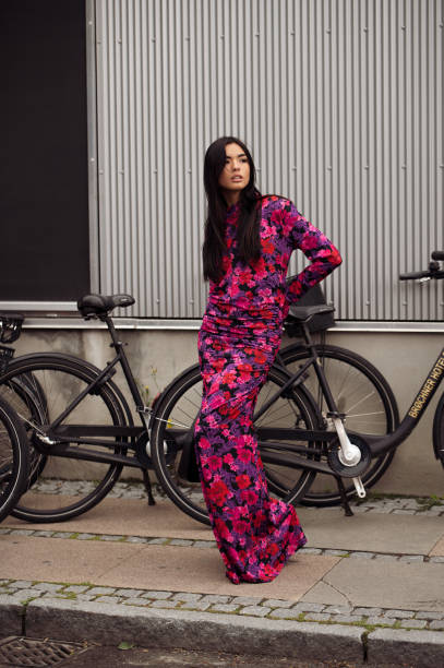 Guest wears a long maxi dress in purple, red, and pink color combination outside Gestuz during the Copenhagen Fashion Week Spring/Summer 2024 on...