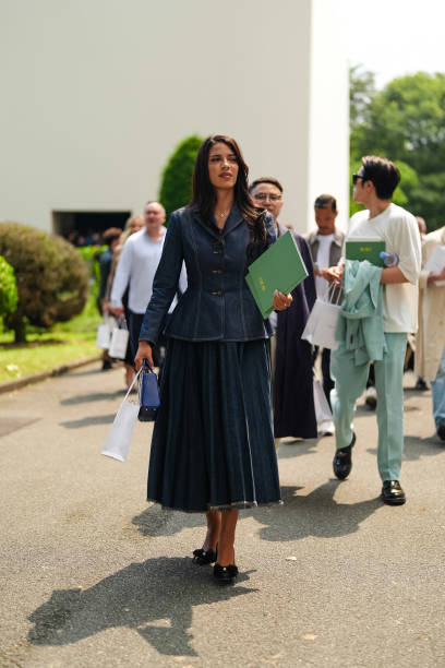 Guest wears a navy blue fitted and lined blazer jacket, navy blue pleated denim jean midi skirt, black Dior leather bag, shiny black with black bows...